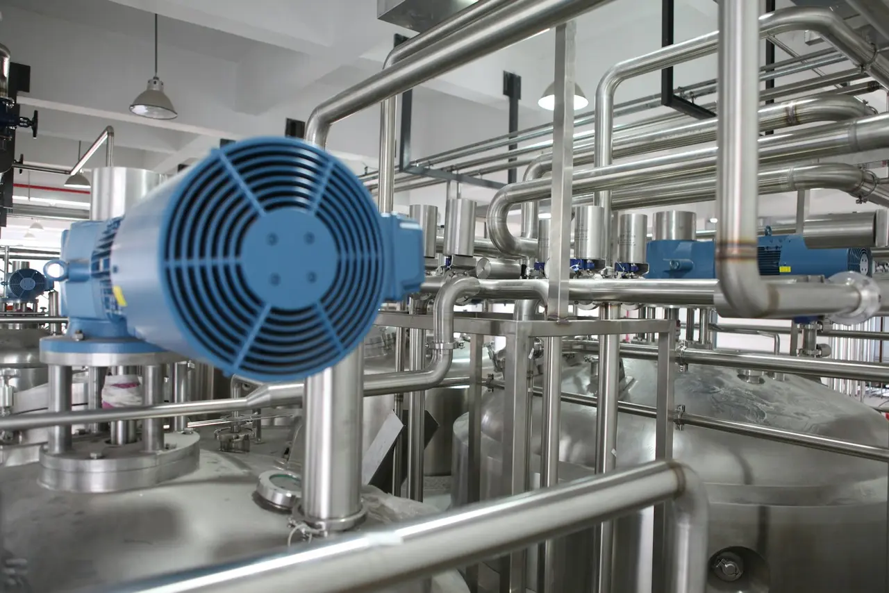 Blue electric motor coupled to stainless steel process pipework